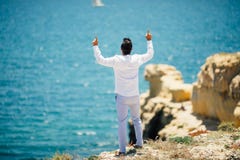 Rear view of Young handsome man pointed up or praying on ocean background stock image Rear view of Young handsome man pointed up or praying on ocean background stock image