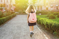 Rear view of young schoolgirl in uniform with backpack going to Royalty Free Stock Images Rear view of young schoolgirl in uniform with backpack going to Royalty Free Stock Images
