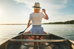 Young woman canoeing on a sunny afternoon in summer stock image Young woman canoeing on a sunny afternoon in summer stock image