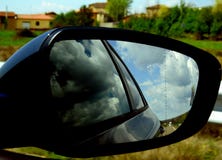 Rearview автомобиля с отражениями облаков стоковая фотография rf Rearview автомобиля с отражениями облаков стоковая фотография rf