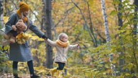 Recht blonde kleine Tochter mit ihrer Mama geht in Herbstpark - haben Sie lustiges und sammeln Sie Blätter Lizenzfreie Stockfotos Recht blonde kleine Tochter mit ihrer Mama geht in Herbstpark - haben Sie lustiges und sammeln Sie Blätter Lizenzfreie Stockfotos