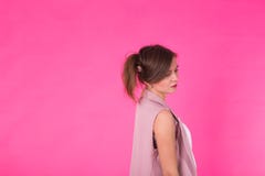 Recht stilvolles Mädchen mit dem langen Haar, das gegen rosa Hintergrund aufwirft Modeporträt der jungen glücklichen lächelnden F lizenzfreies stockbild Recht stilvolles Mädchen mit dem langen Haar, das gegen rosa Hintergrund aufwirft Modeporträt der jungen glücklichen lächelnden F lizenzfreies stockbild