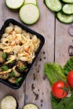 Recipiente di plastica con le ali di pollo arrostite e le verdure crude su fondo rustico, insalata delle verdure immagine stock libera da diritti Recipiente di plastica con le ali di pollo arrostite e le verdure crude su fondo rustico, insalata delle verdure immagine stock libera da diritti