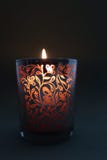 Recipiente gravado de incandescência da vela chama que cria um fulgor morno imagem de stock Recipiente gravado de incandescência da vela chama que cria um fulgor morno imagem de stock