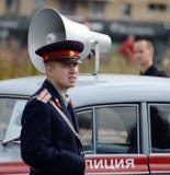 A reconstructor in the Soviet uniform of a police officer at the Moskvich-401 car at an exhibition of old transport. Stock Photo A reconstructor in the Soviet uniform of a police officer at the Moskvich-401 car at an exhibition of old transport. Stock Photo