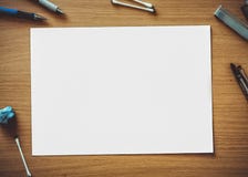 A rectangular chart put on a brown coloured wooden table and a lollipop candy, pens and other objects are placed around this chart royalty free stock photos A rectangular chart put on a brown coloured wooden table and a lollipop candy, pens and other objects are placed around this chart royalty free stock photos