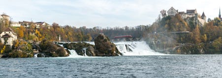 A red arrow train stops on top of the bridge at Rhine Falls to view the wonderful waterfall landscape and the castle at Laufen in stock images A red arrow train stops on top of the bridge at Rhine Falls to view the wonderful waterfall landscape and the castle at Laufen in stock images