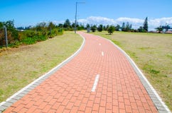 Red brick cycle path and footpath in the park with green field. stock photography Red brick cycle path and footpath in the park with green field. stock photography