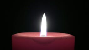 Red Candle With Flame Against Black Background
