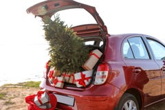 Red Car With Gift Boxes And Christmas Tree On Beach. Royalty Free Stock Photography