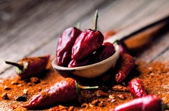 Red chilli peppers, spicy on a wooden spoon. Vegetable on a dark, wooden table. Concept of hot food. stock images Red chilli peppers, spicy on a wooden spoon. Vegetable on a dark, wooden table. Concept of hot food. stock images