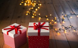 Red Gift Boxes And Christmas Lights On Wooden Floor Royalty Free Stock Images