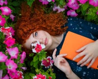 Red-haired girl lies in wild flowers. royalty free stock photos Red-haired girl lies in wild flowers. royalty free stock photos