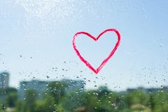 Red heart painted with lipstick on the window with water drops. Background blue sunny sky, drops shine in the sun. Royalty Free Stock Photo Red heart painted with lipstick on the window with water drops. Background blue sunny sky, drops shine in the sun. Royalty Free Stock Photo