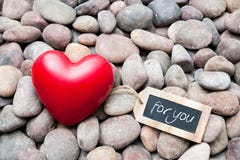 Red heart on pebble stones with tag stock photography Red heart on pebble stones with tag stock photography