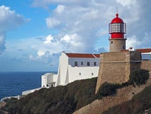 Red lighthouse on Cabo de Sao Vicente with stone wall stock image Red lighthouse on Cabo de Sao Vicente with stone wall stock image