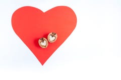 Red paper heart and two halves of walnut in shape of heart on it on white background. stock photos Red paper heart and two halves of walnut in shape of heart on it on white background. stock photos