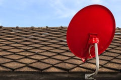 Red Satellite TV Receiver Dish on the Old Tiles Roof Royalty Free Stock Photography Red Satellite TV Receiver Dish on the Old Tiles Roof Royalty Free Stock Photography