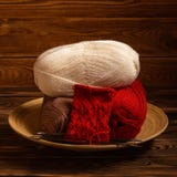 Red and white colored balls of thread and knitting needles with a knitting on a wooden background royalty free stock photos Red and white colored balls of thread and knitting needles with a knitting on a wooden background royalty free stock photos
