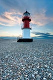Red and white lighthouse on a beach with pebbles Stock Photography Red and white lighthouse on a beach with pebbles Stock Photography