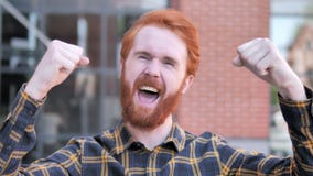 Redhead beard young man celebrating success outdoor stock video footage Redhead beard young man celebrating success outdoor stock video footage