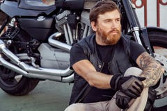 Redhead biker with beard in leather jacket and his bike. royalty free stock images Redhead biker with beard in leather jacket and his bike. royalty free stock images