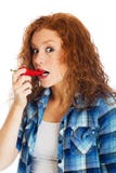 Redhead γυναίκα που παίρνει το δάγκωμα του πικάντικου κόκκινου πιπεριού Στοκ Εικόνες Redhead γυναίκα που παίρνει το δάγκωμα του πικάντικου κόκκινου πιπεριού Στοκ Εικόνες