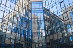 Reflection in a square glass-fronted façade. Architectural abstraction stock image Reflection in a square glass-fronted façade. Architectural abstraction stock image