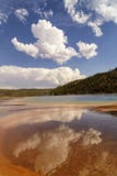 Reflexão das nuvens na mola prismático grande na bacia intermediária do geyser no parque nacional de Yellowstone foto de stock Reflexão das nuvens na mola prismático grande na bacia intermediária do geyser no parque nacional de Yellowstone foto de stock