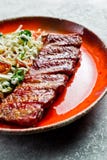 Refor?os de carne de porco americanos tradicionais do assado com um prato lateral da salada verde Backgroun cinzento imagens de stock Refor?os de carne de porco americanos tradicionais do assado com um prato lateral da salada verde Backgroun cinzento imagens de stock