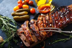 Reforços assados deliciosos temperados com um molho de aspersão picante e servidos com desbastado foto de stock royalty free Reforços assados deliciosos temperados com um molho de aspersão picante e servidos com desbastado foto de stock royalty free
