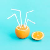 Refreshing concept with orange juice and straw in pastel color Stock Photo Refreshing concept with orange juice and straw in pastel color Stock Photo