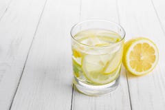 Refreshing drink for health, lemon water in a glass and yellow linden flowers on a white table stock photos Refreshing drink for health, lemon water in a glass and yellow linden flowers on a white table stock photos