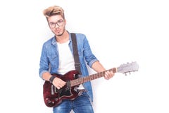 Refrigere o guitarrista ocasional que joga sua guitarra elétrica vermelha fotos de stock royalty free Refrigere o guitarrista ocasional que joga sua guitarra elétrica vermelha fotos de stock royalty free