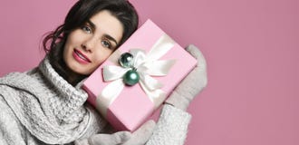 Regalo del asimiento del retrato de la mujer joven Muchacha feliz sonriente en fondo rosado imagen de archivo Regalo del asimiento del retrato de la mujer joven Muchacha feliz sonriente en fondo rosado imagen de archivo