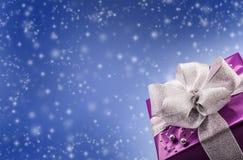 Regalo púrpura de la Navidad o de la tarjeta del día de San Valentín con el fondo de plata del azul del extracto de la cinta imagen de archivo libre de regalías Regalo púrpura de la Navidad o de la tarjeta del día de San Valentín con el fondo de plata del azul del extracto de la cinta imagen de archivo libre de regalías