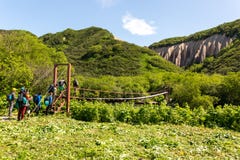 Región de Petravlosk-Kamchatsky, Rusia - 18 de julio de 2018: Grupo de turistas que cruzan el río en puente colgante imágenes de archivo libres de regalías Región de Petravlosk-Kamchatsky, Rusia - 18 de julio de 2018: Grupo de turistas que cruzan el río en puente colgante imágenes de archivo libres de regalías