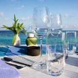 Regolazione della Tabella al ristorante della spiaggia immagini stock Regolazione della Tabella al ristorante della spiaggia immagini stock