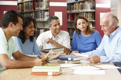 Reife Studenten, die in der Bibliothek arbeiten lizenzfreie stockbilder Reife Studenten, die in der Bibliothek arbeiten lizenzfreie stockbilder