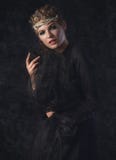 Reine d'obscurité dans le costume noir d'imagination sur le fond gothique foncé Modèle de beauté de haute couture avec le maquill Photos stock Reine d'obscurité dans le costume noir d'imagination sur le fond gothique foncé Modèle de beauté de haute couture avec le maquill Photos stock