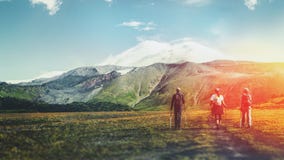 Reiseziel-Erfahrungs-Lebensstil-Konzeptkonzept Team von Reisenden mit Rucksäcken und Trekkingsstöcken klettert den Berg lizenzfreies stockbild Reiseziel-Erfahrungs-Lebensstil-Konzeptkonzept Team von Reisenden mit Rucksäcken und Trekkingsstöcken klettert den Berg lizenzfreies stockbild
