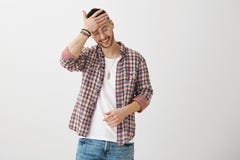 Reizend Kerl mit der Modegeschmackreibungsstirn und unten -schauen beim Lächeln oder Lachen, verwirrend mit Lizenzfreies Stockfoto Reizend Kerl mit der Modegeschmackreibungsstirn und unten -schauen beim Lächeln oder Lachen, verwirrend mit Lizenzfreies Stockfoto