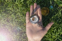 Rel?gio de bolso do vintage na m?o masculina em um fundo da grama verde Rel?gio de Steampunk O mecanismo do pulso de disparo ? pa imagem de stock royalty free Rel?gio de bolso do vintage na m?o masculina em um fundo da grama verde Rel?gio de Steampunk O mecanismo do pulso de disparo ? pa imagem de stock royalty free