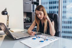 Relatório financeiro do readind fêmea da mulher de negócios que analisa as estatísticas que apontam na carta de torta que trabalh imagens de stock Relatório financeiro do readind fêmea da mulher de negócios que analisa as estatísticas que apontam na carta de torta que trabalh imagens de stock