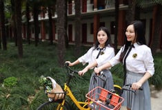 Relax Asian Chinese Pretty Girls Wear Student Suit In School Enjoy Free Time Ride Bike In Nature Spring Garden Royalty Free Stock Photography