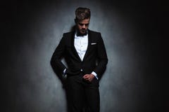 Relaxed businessman leaning against a black wall while looking d royalty free stock photos Relaxed businessman leaning against a black wall while looking d royalty free stock photos