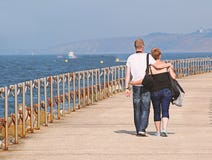 Relaxed holiday couple walking along a seaside pier
