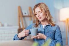 Relaxed Young Woman Sitting And Looking At The Cup Of Tea Stock Photos Relaxed Young Woman Sitting And Looking At The Cup Of Tea Stock Photos