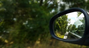 Relflection della strada e degli alberi in wingmirror dell'automobile fotografie stock libere da diritti Relflection della strada e degli alberi in wingmirror dell'automobile fotografie stock libere da diritti