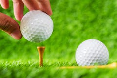Remettez la boule de golf de prise mise sur le bois de brun de pièce en t avec le backg d'herbe verte image libre de droits Remettez la boule de golf de prise mise sur le bois de brun de pièce en t avec le backg d'herbe verte image libre de droits